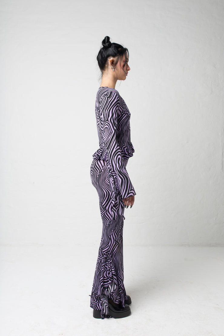 fashion brand BONDY showcasing handmade SERAPHINA purple and black abstract high waisted side slit flare pants/trousers shown on a size small model, part of the new DREY:MA collection. full body side view