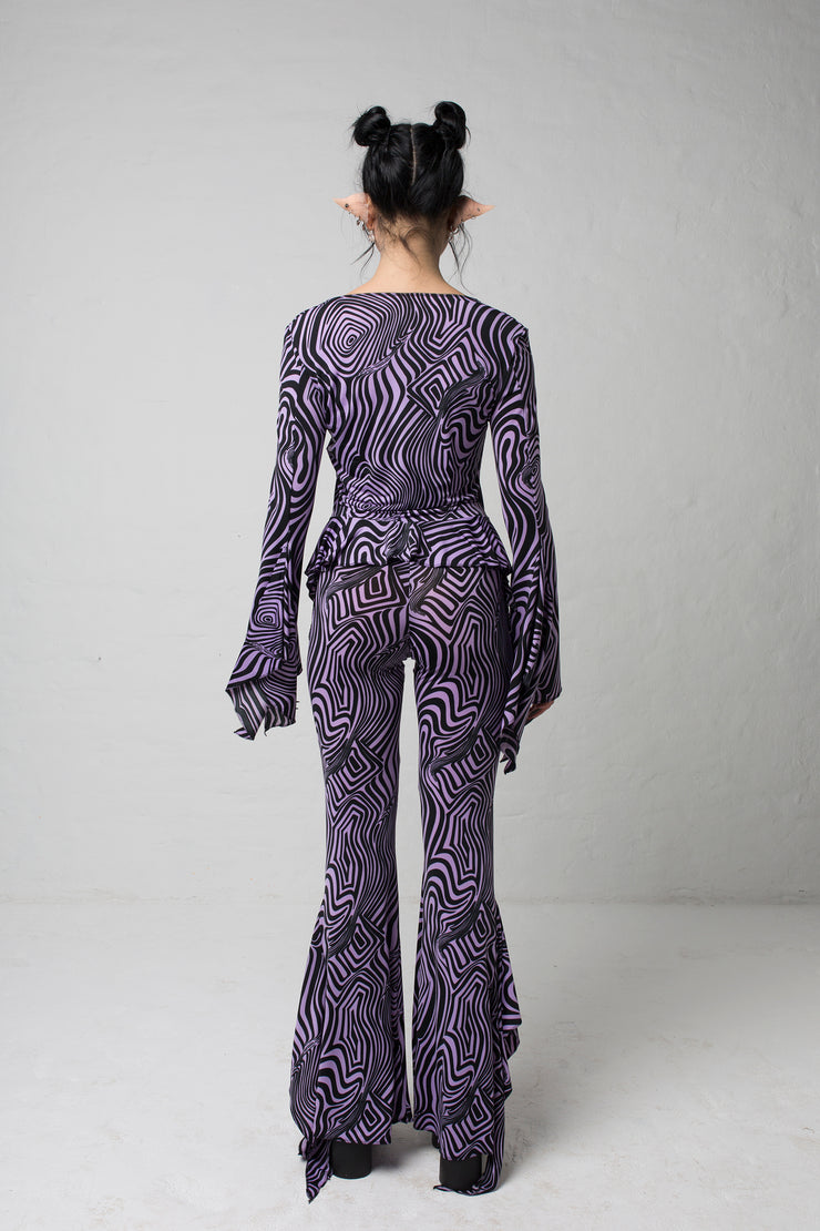 fashion brand BONDY showcasing handmade SERAPHINA purple and black abstract high waisted side slit flare pants/trousers shown on a size small model, part of the new DREY:MA collection. full body back view