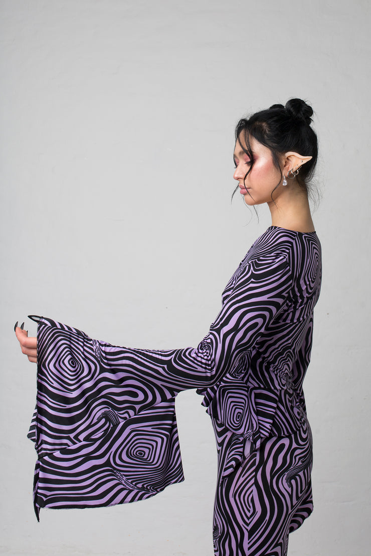 fashion brand BONDY photoshoot showcasing handmade AURORA abstract long-sleeve purple and black flare top on size small model, part of new collection DREY:MA. side view