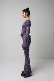 fashion brand BONDY photoshoot showcasing handmade AURORA abstract long-sleeve purple and black flare top on size small model, part of new collection DREY:MA. full body side view