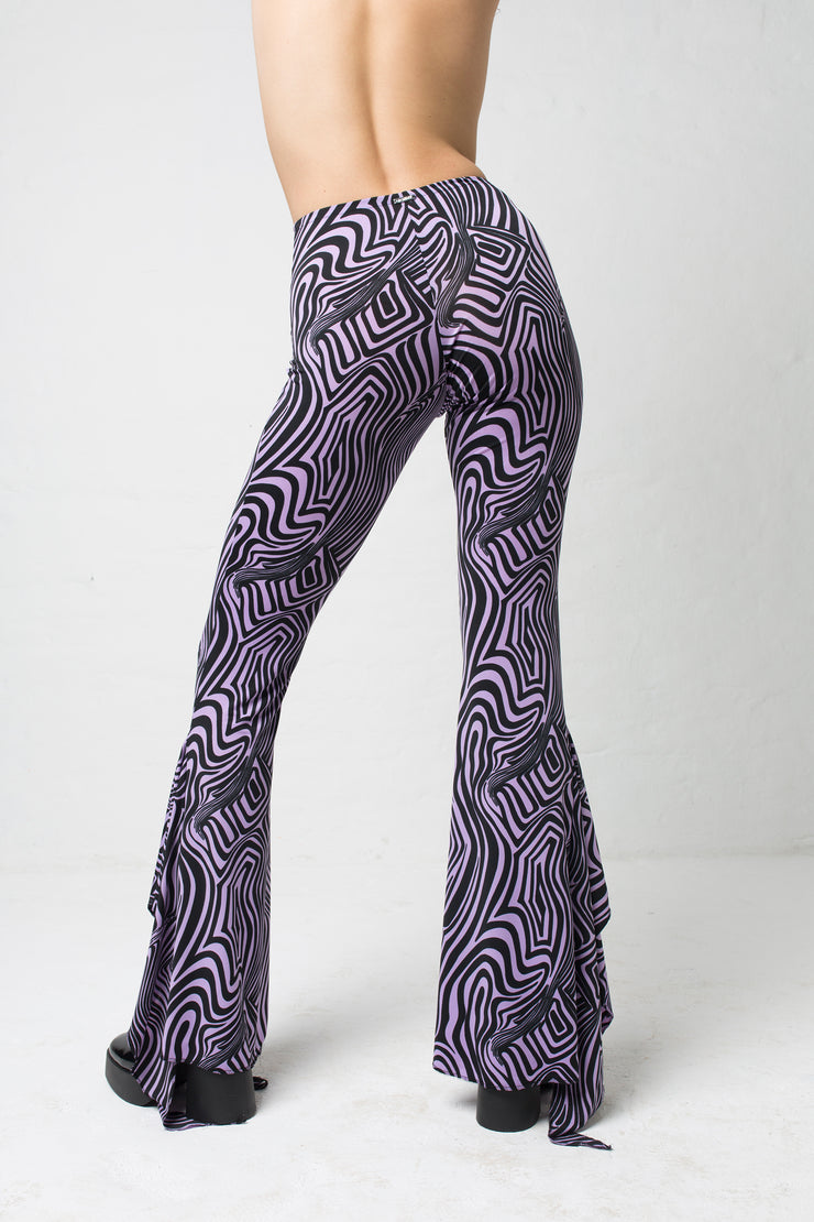 fashion brand BONDY showcasing handmade SERAPHINA purple and black abstract high waisted side slit flare pants/trousers shown on a size small model, part of the new DREY:MA collection. back view