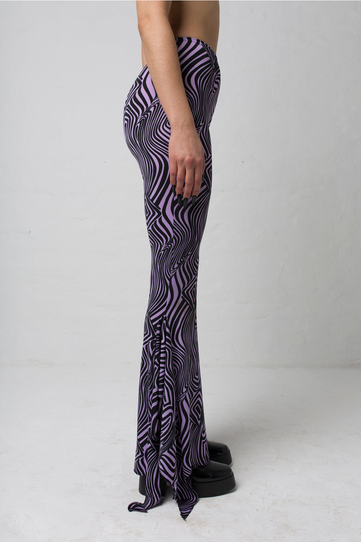 fashion brand BONDY showcasing handmade SERAPHINA purple and black abstract high waisted side slit flare pants/trousers shown on a size small model, part of the new DREY:MA collection. side view