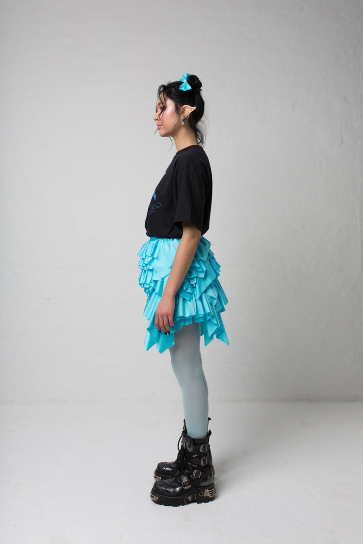 fashion brand BONDY photoshoot showcasing handmade CASSIA mini ruffle ice blue skirt shown on size small model, part of new collection DREY:MA. full body side view